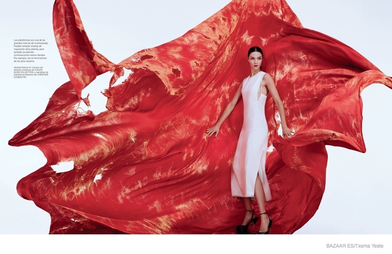 With tattered red fabric behind her, Mariacarla stuns in a white Calvin Klein Collection dress