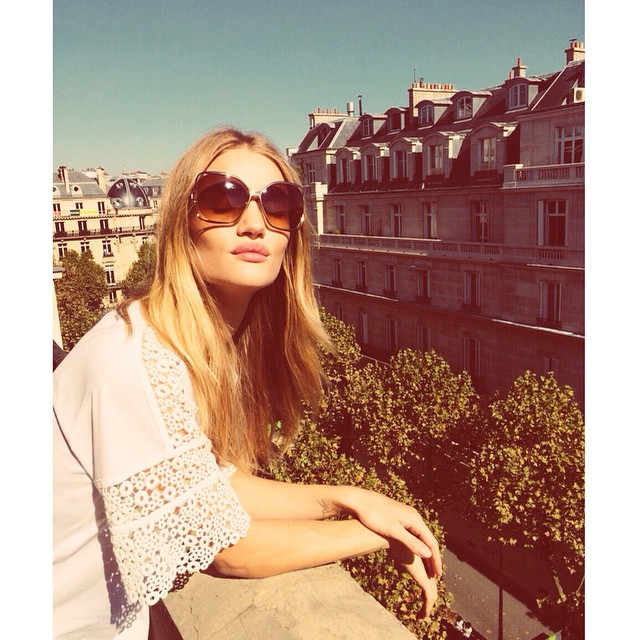 Rosie Huntington Whiteley wears 60s style sunglasses and a white dress in Paris. Photo via Instagram. 