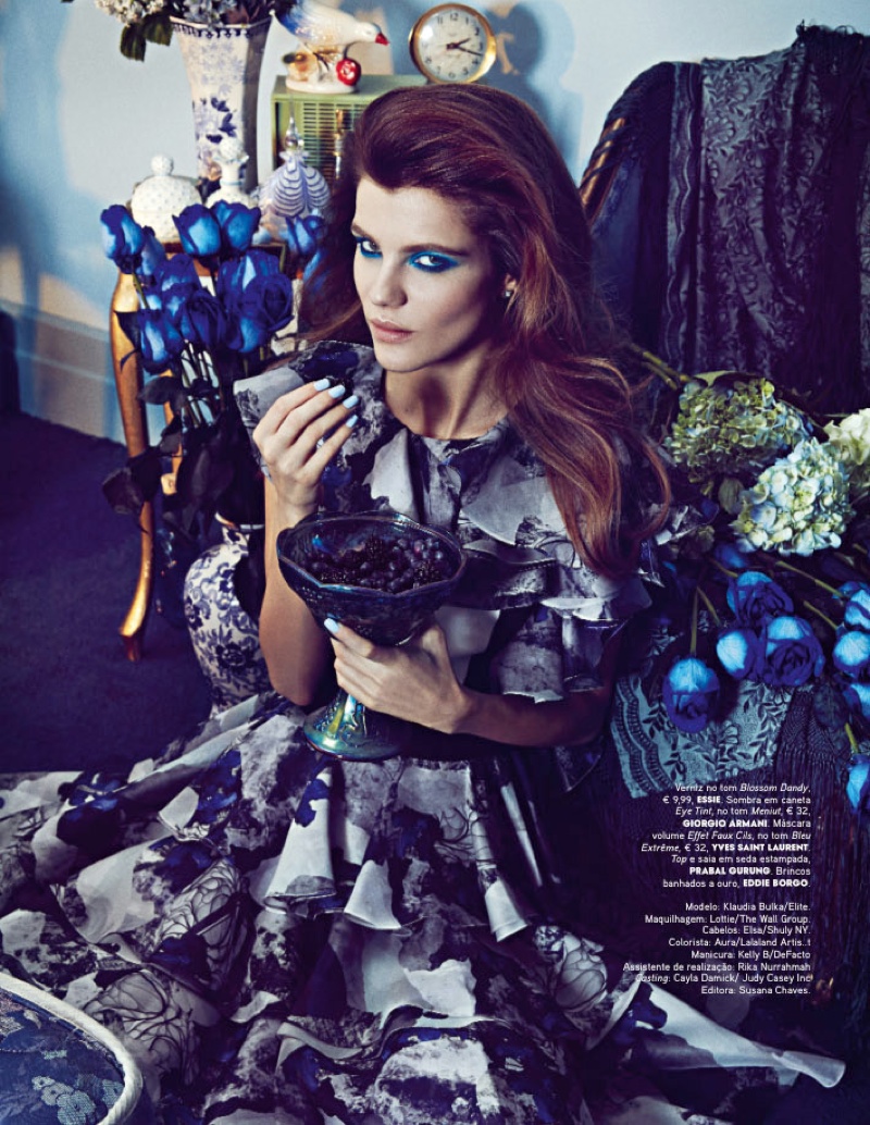 Surrounded by blue flowers, the model wears a floral print dress from Prabal Gurung