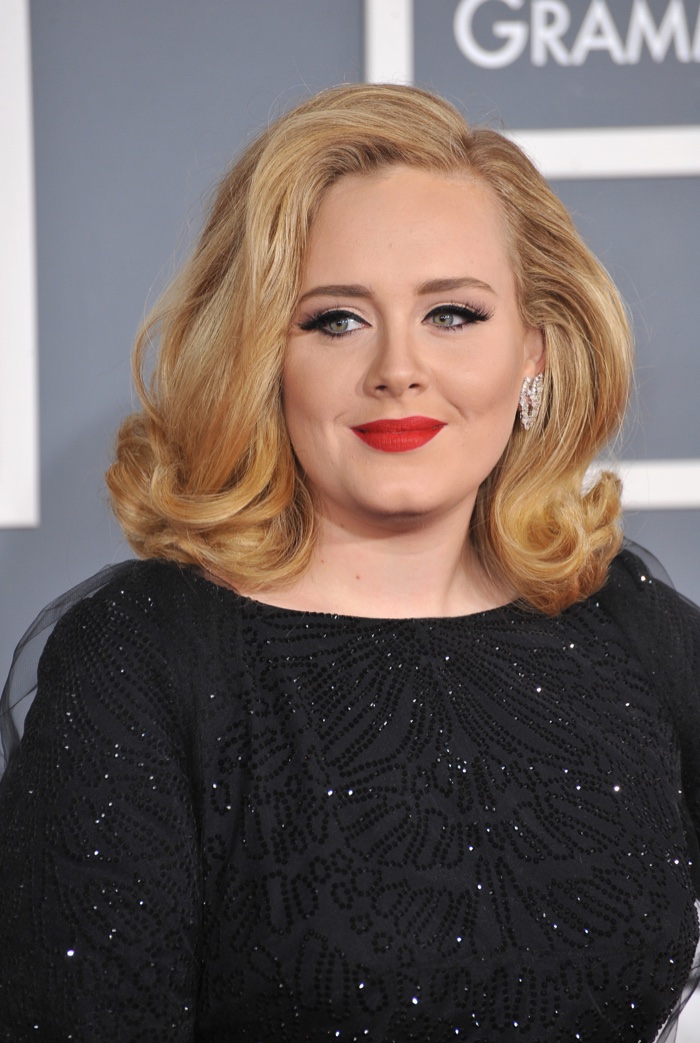 Adele wears medium length hairstyle with flipped curls and side part. Photo: Featureflash / Shutterstock.com