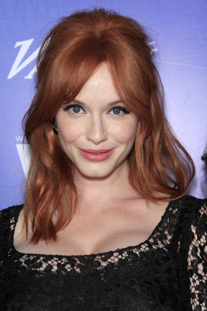 Christina Hendricks shows off wavy half up, half down hairstyle for medium length hair with parted bangs. Photo: Helga Esteb / Shutterstock.com