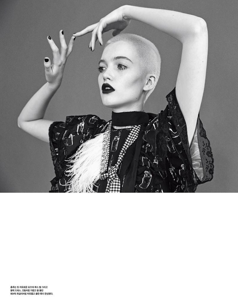 Photographed in black and white, the model wears a dark lip color with an embellished top