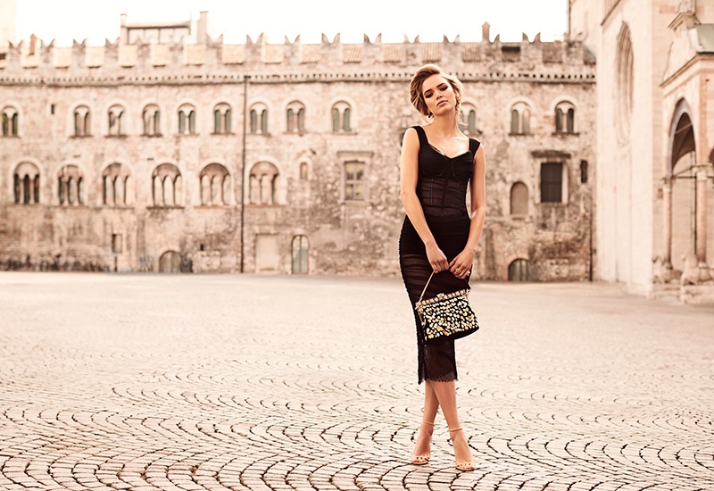 Zo Nowak wears a black Dolce & Gabbana dress and bags with Jimmy Choo heels