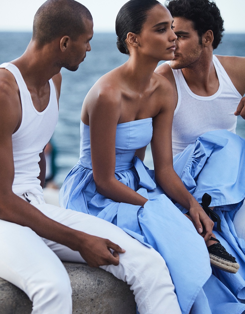 Posing with two hunky male models, Cora Emmanuel wears strapless blue dress with espadrilles
