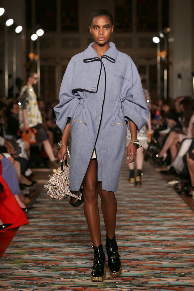 A model walks the runway at Dior’s cruise 2017 show wearing a blue cotton tweed coat