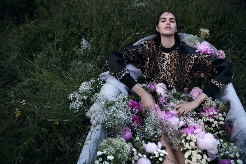 Taking a moment to relax, the model poses in a bathtub full of flowers