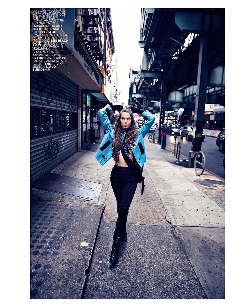 Hitting the streets, the model wears jacket, pants, sweater and boots from Versace