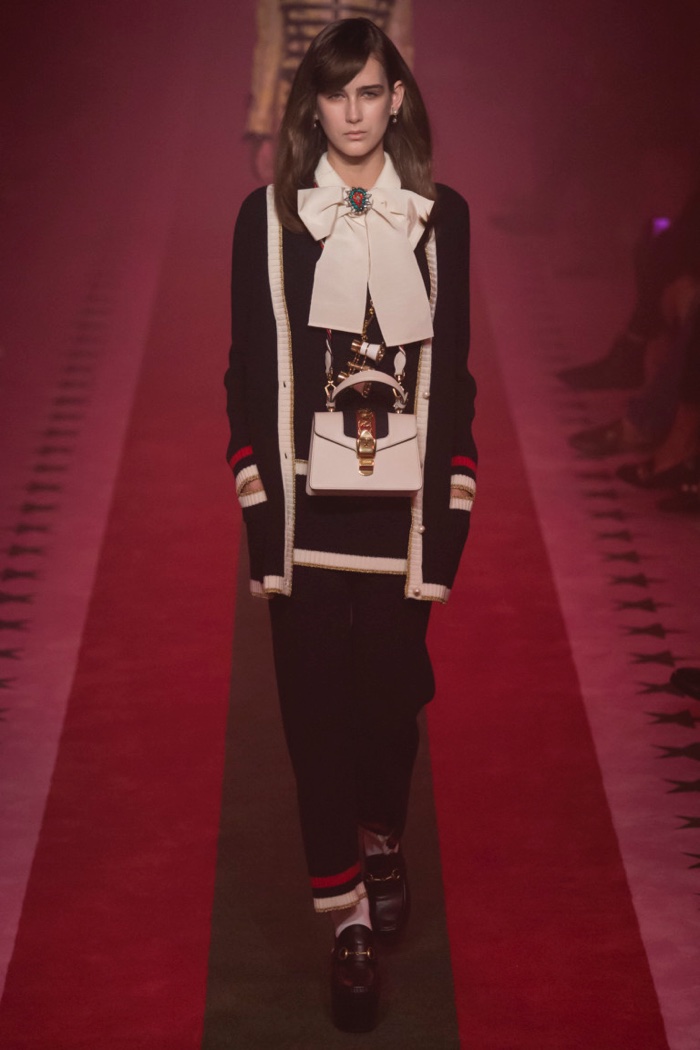 Gucci Spring 2017: Model walks the runway in cardigan sweater over long blouse and pants with stripe trim