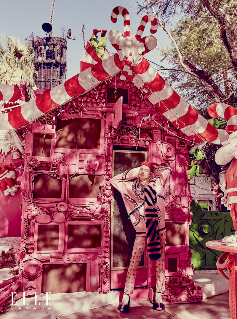 The model looks pretty in pink posing next to a candy cane house