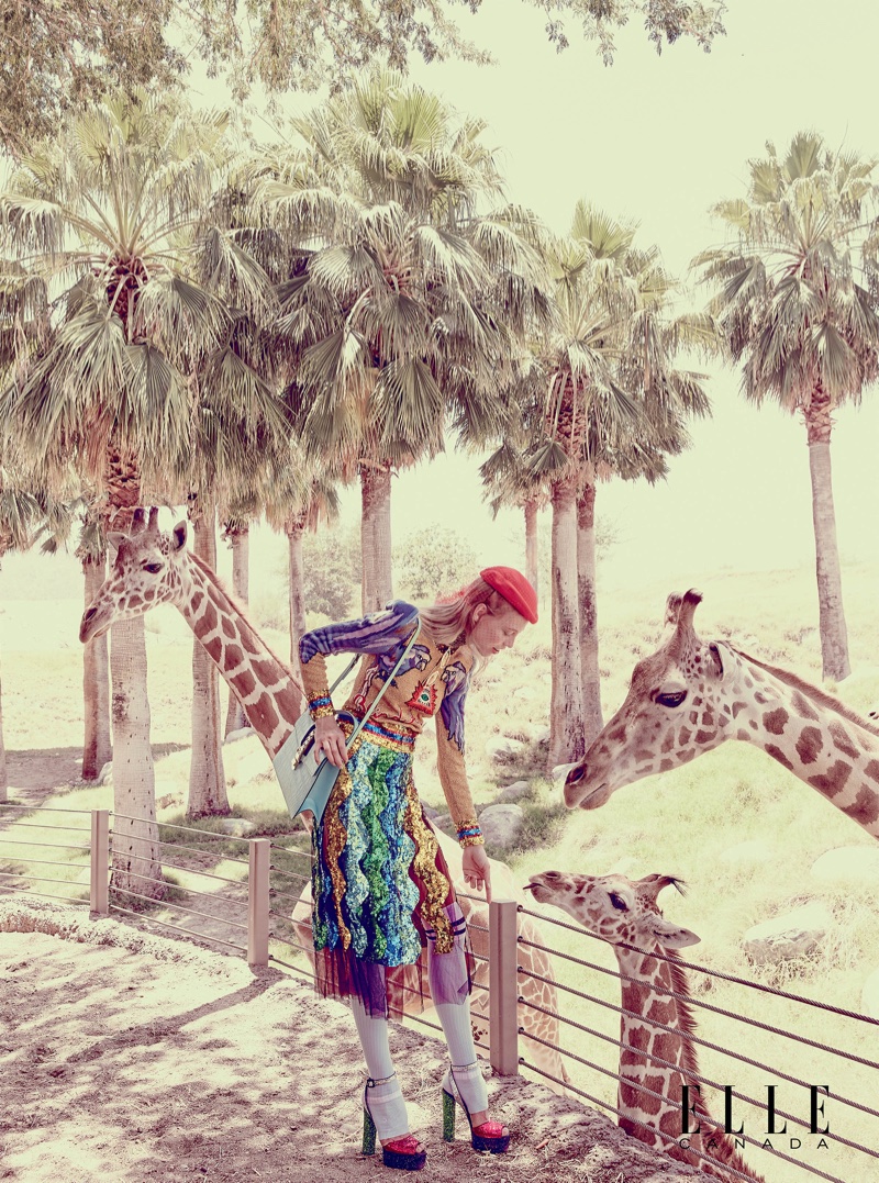 Laura Schellenberg visits with giraffes in Gucci top, skirt, bag, hat and glasses with Giuseppe Zanotti platform sandals
