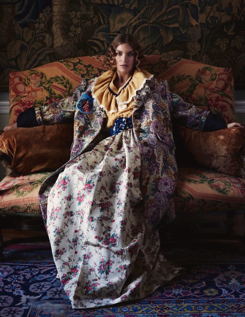 Taking a seat, Arizona Muse wears Miu Miu floral brocade coat over shirt and maxi skirt
