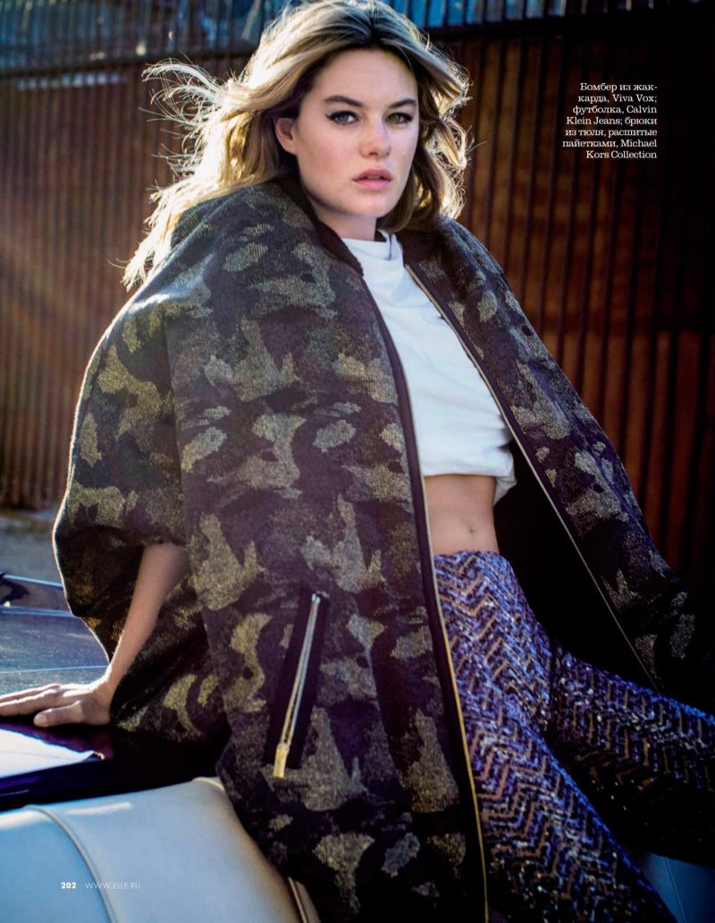 Model Camille Rowe layers up in oversized sweater, cropped top and sequined pants