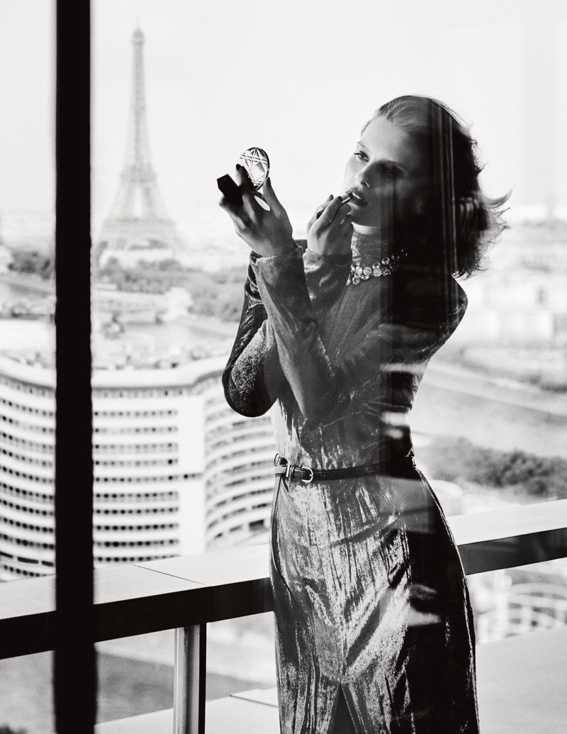 Touching up her makeup, the model wears a shimmering dress