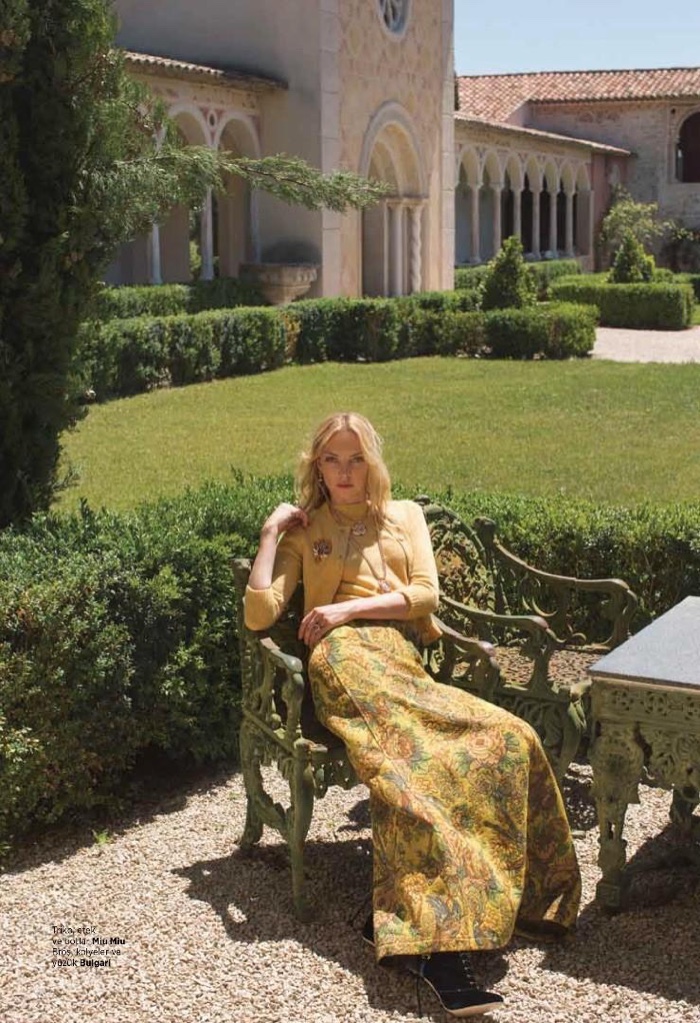 Lounging outdoors, Heather Marks models Miu Miu cardigan, top, skirt and boots with Bulgari jewelry