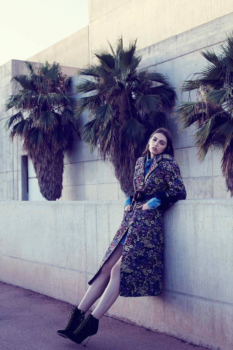 Model Anisia Khurmatulina wears brocade Miu Miu coat, dress and boots with Blumarine belt