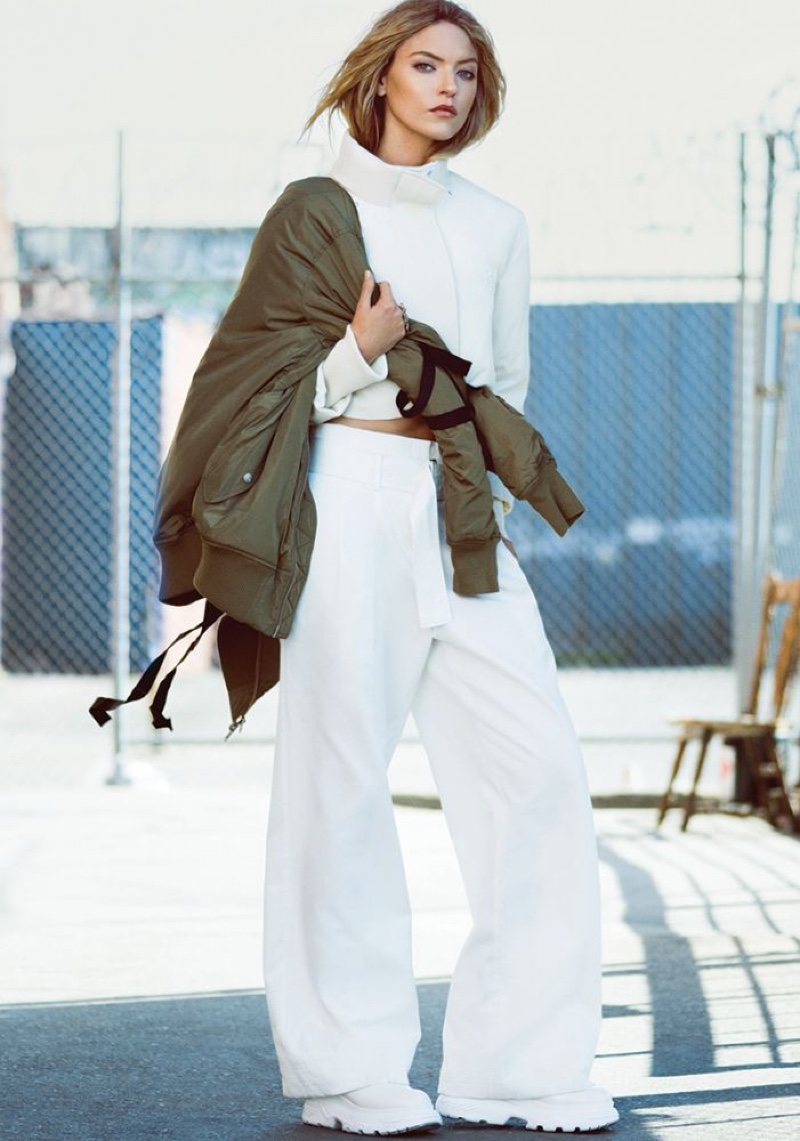 Covering up, Martha Hunt poses in high-necked jacket with wide-leg pants and green bomber