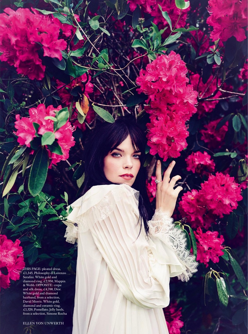 Posing with flowers, the model wears a pleated Philosophy di Lorenzo Serafini dress