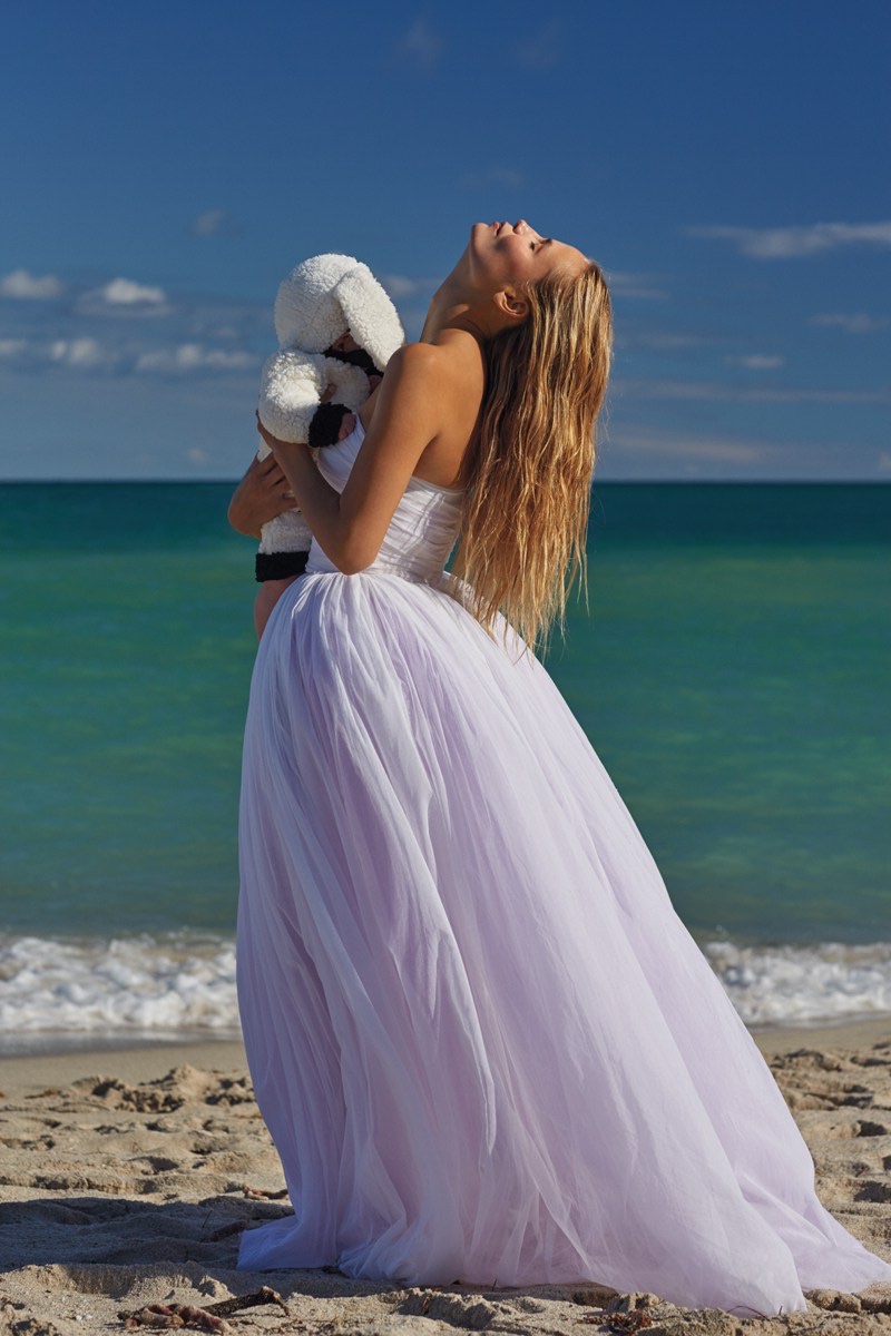 Posing on the sand, Natasha Poly models Juan Gatti dress