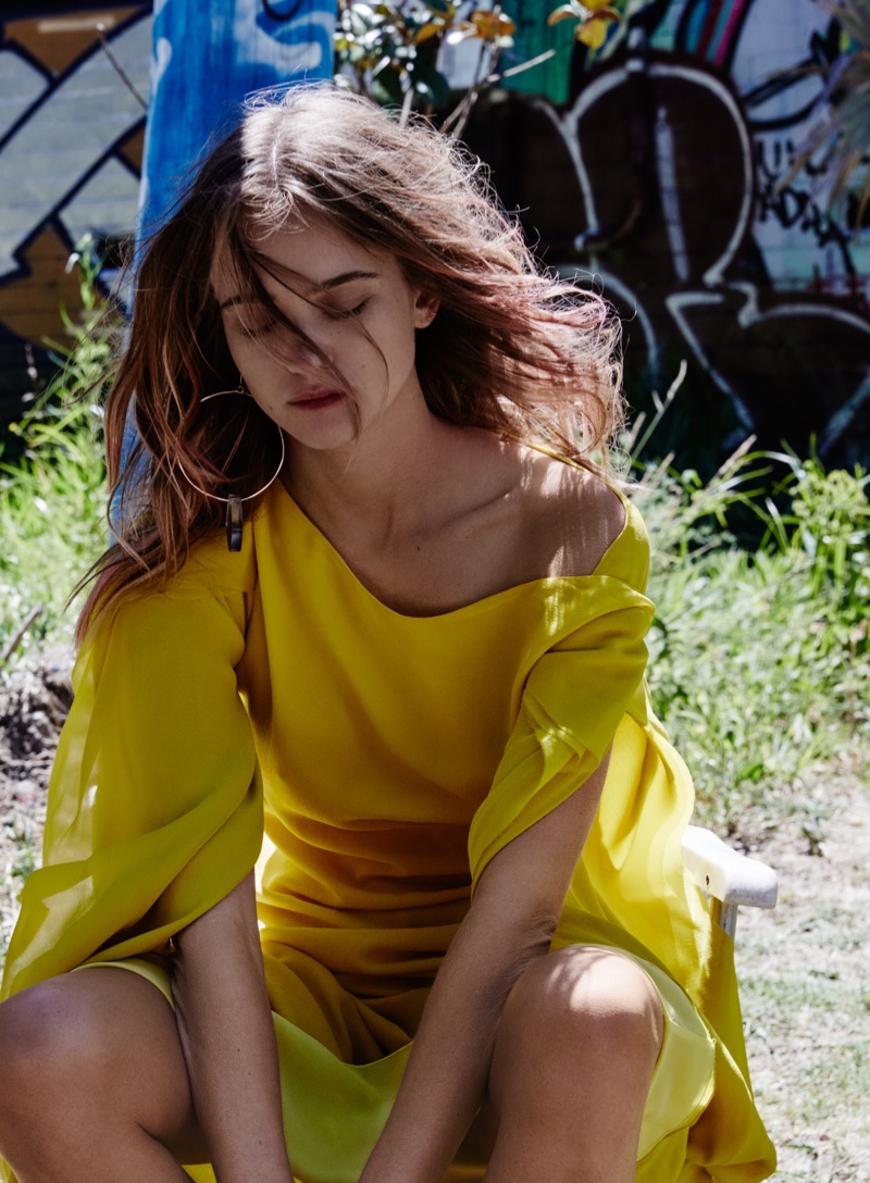 Posing outdoors, Rosie Tupper wears Bianca Spender gown with Ginger & Smart hoop earring