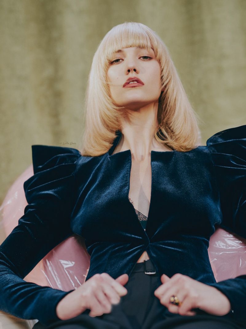 Showing off a platinum blonde hairstyle with fringe, Karlie Kloss wears a velvet jacket