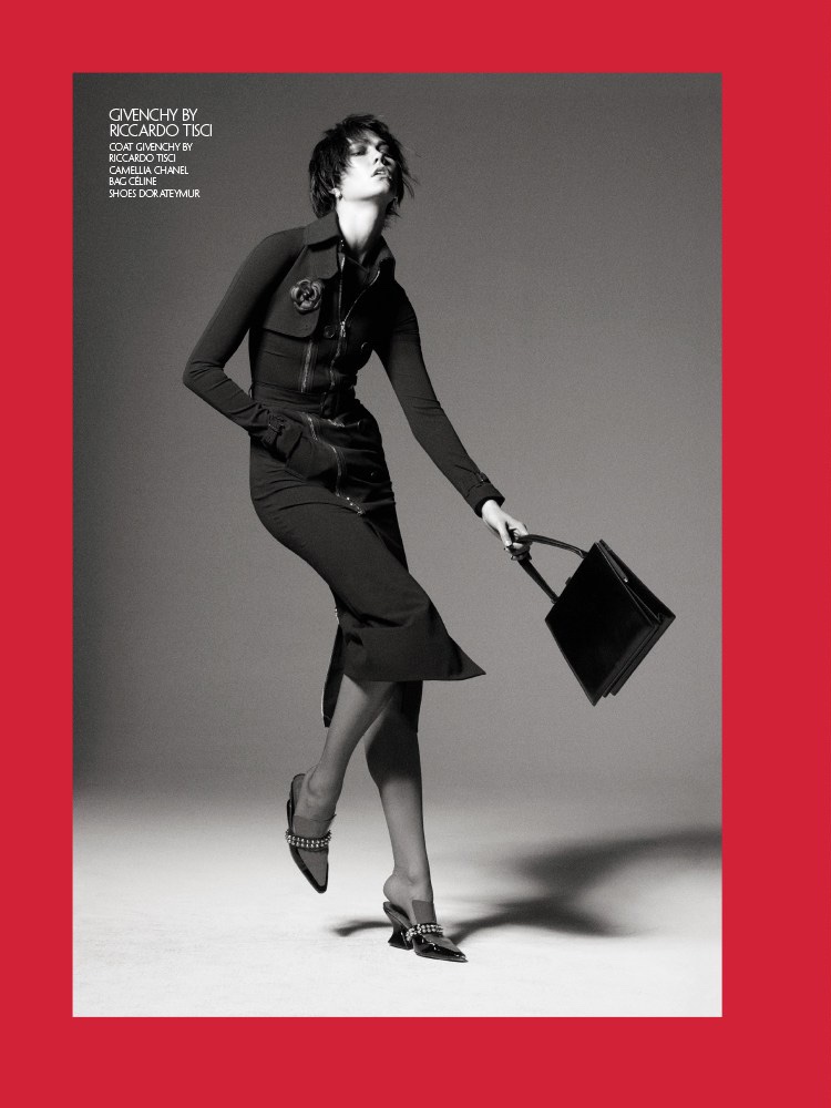 Photographed in black and white, Karlie Kloss models Givenchy coat, Chanel Camellia broach, Celine bag and Dorateymur shoes