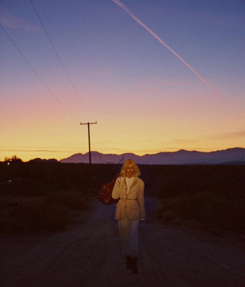 Walking a desert road, Edita Vilkeviciute models Giorgio Armani jacket and pants with Aquilano.Rimondi shirt
