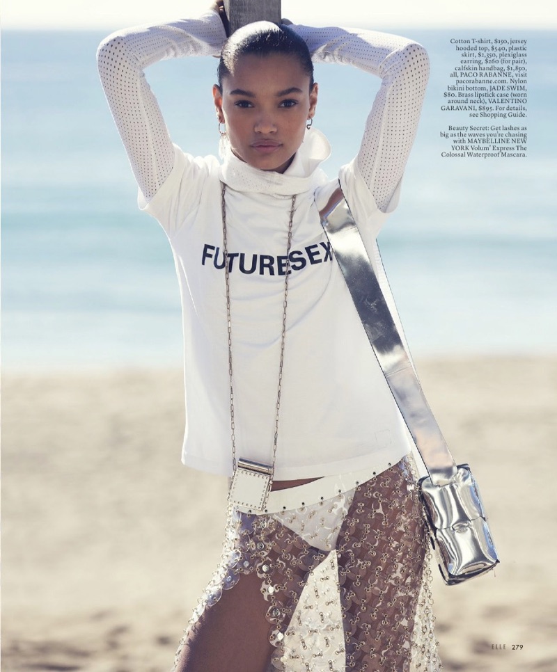 Lameka Fox poses in Paco Rabanne t-shirt, hooded top, plastic skirt, earrings and handbag