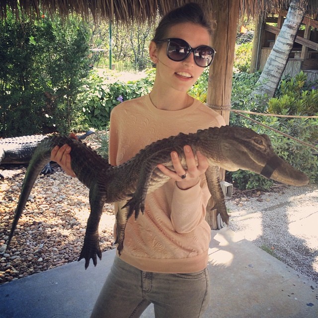 Karlina Caune takes a photo with alligator 