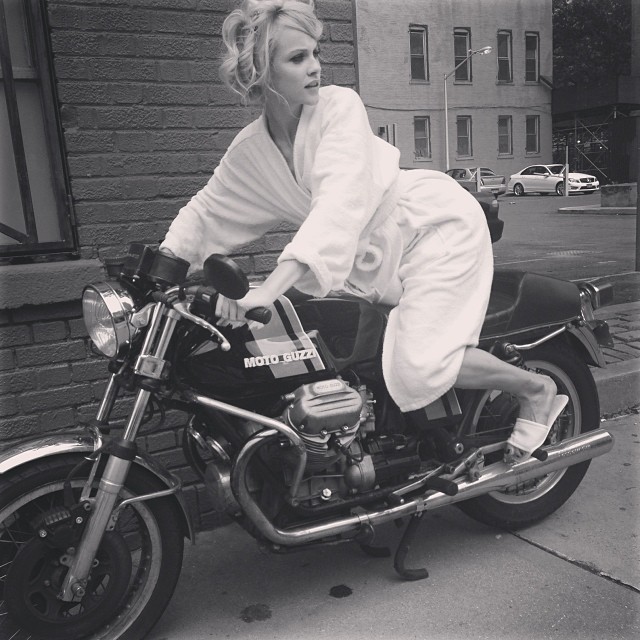 Ginta Lapina poses on a motorcycle in a bath robe