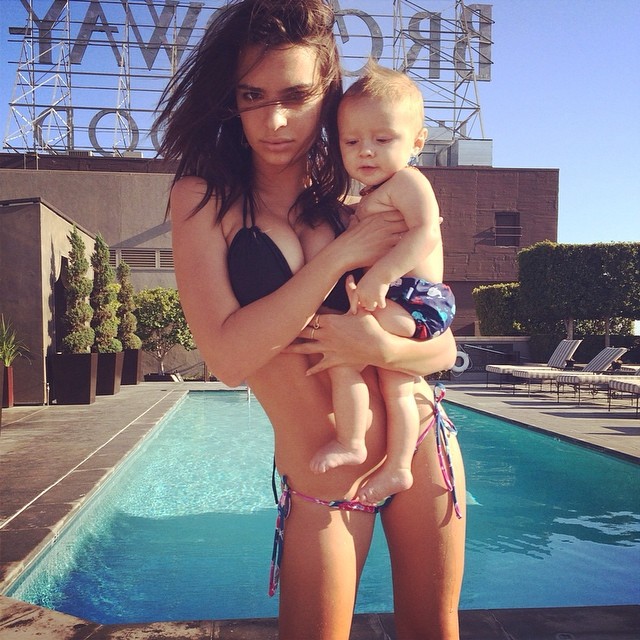 Emily Ratajkowski baby sits in a bikini
