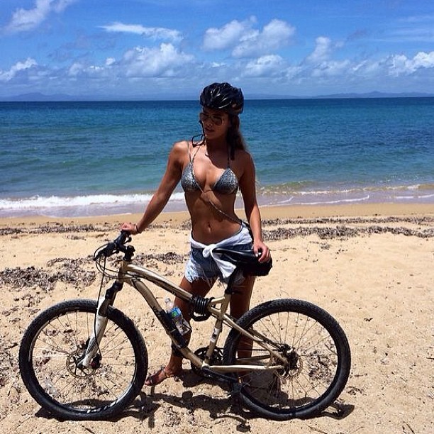 Nina Agdal on the sand with a bike