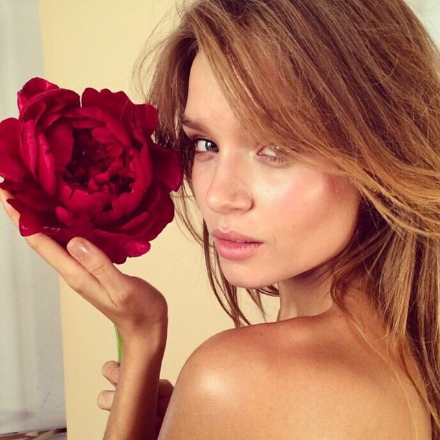 Josephine Skriver poses with a red flower