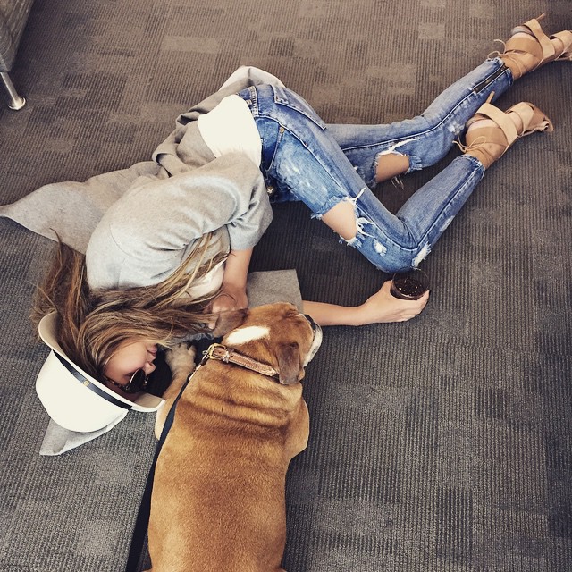 Chrissy Teigen gets on ground level with a dog