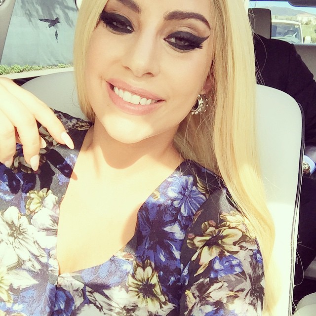 Lady Gaga shows a glammed out look with a blonde wig and big eyelashes. 