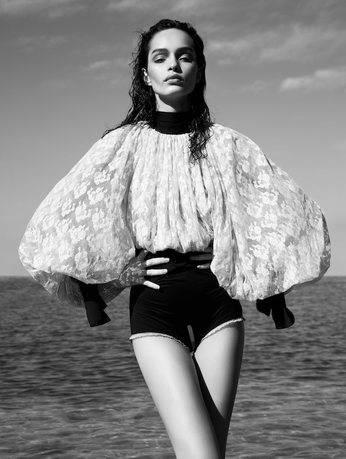 Luma models a dramatic top with puffy sleeves in this image. 