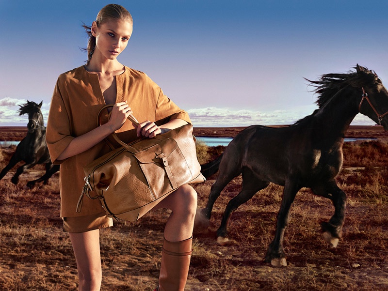 Anna Sezneva models a large tote, riding boots and an oversized shirt from Massimo Dutti. 