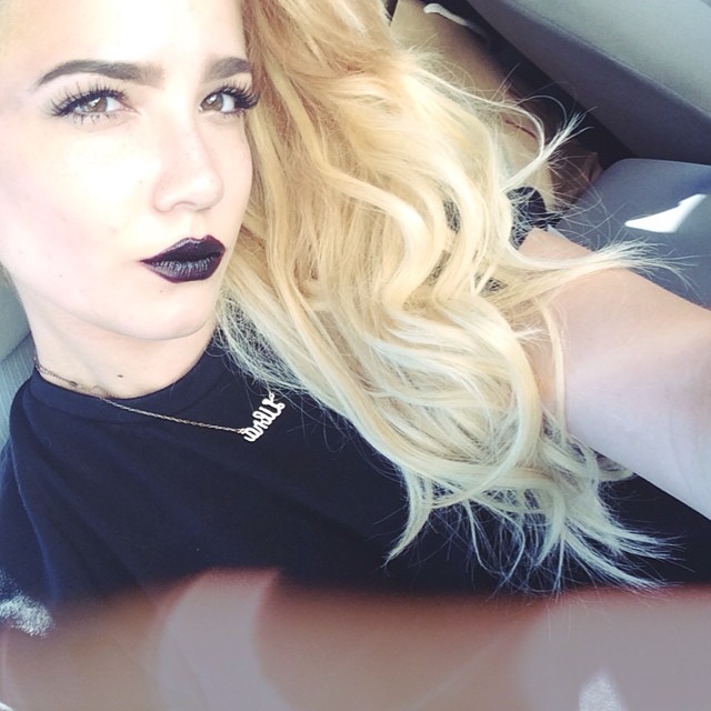 Halsey sports long blonde waves with a dark lipstick shade