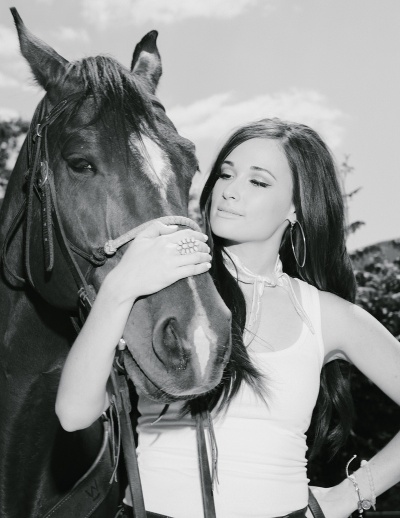 The country music singer poses with a horse in this image
