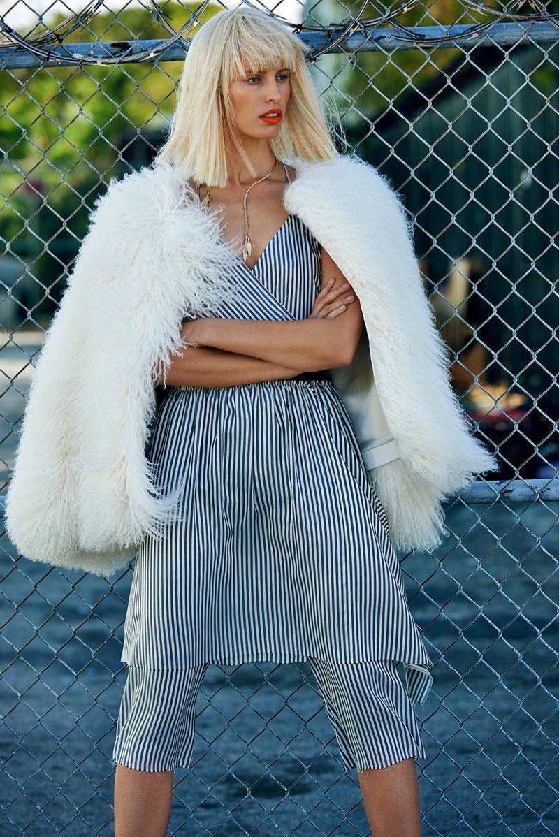 Karolina looks glam in a furry jacket with a striped dress and pants