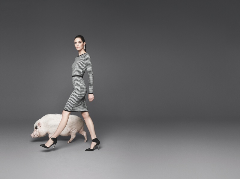 The model poses with animal co-stars like a pig