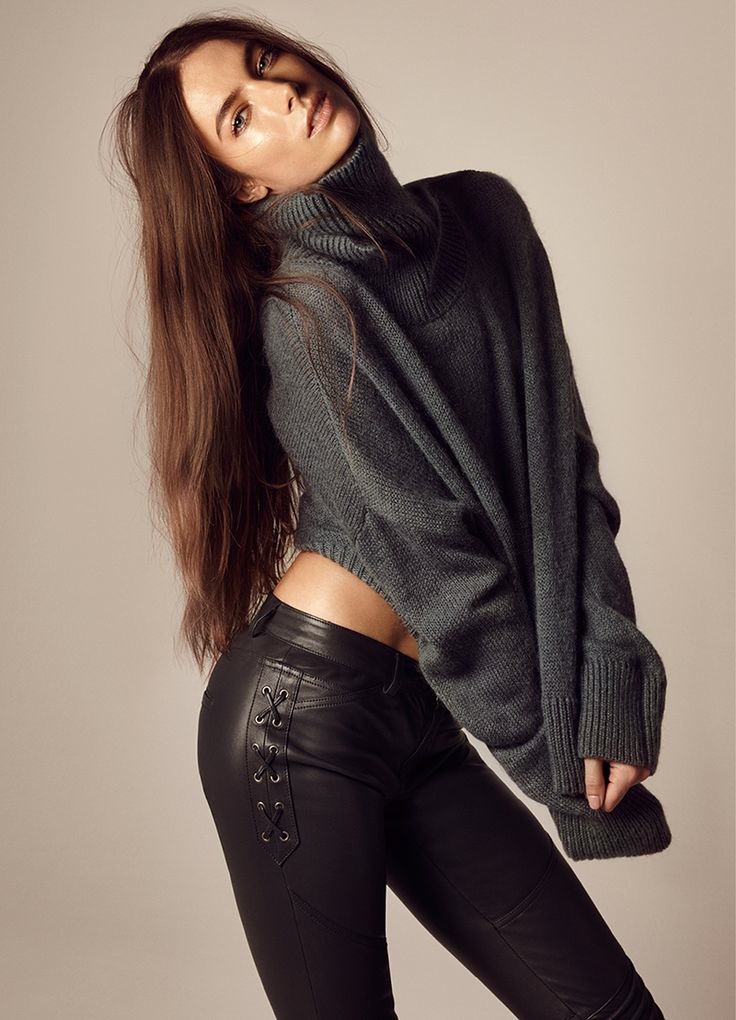 Jessica poses in a charcoal grey sweater and slim-fit pants