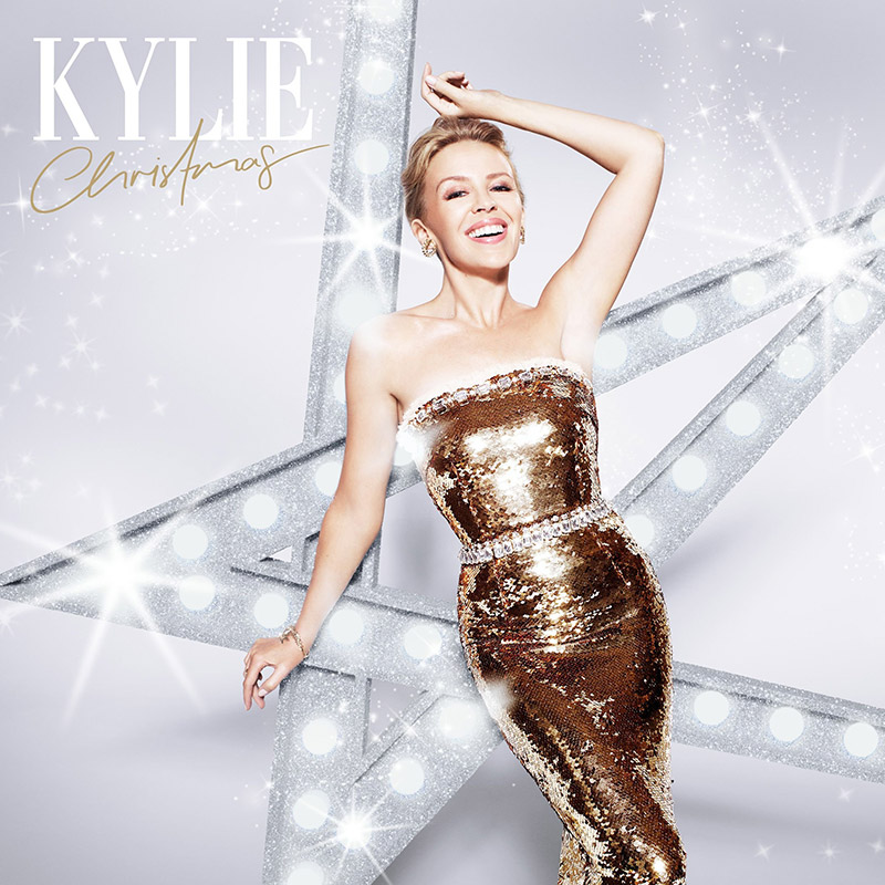 Kylie Minogue glitters in a gold dress on her album cover for ‘Kylie Christmas’. Out on November 13, the new release features timeless classics as well as duets with Iggy Pop and James Corden.