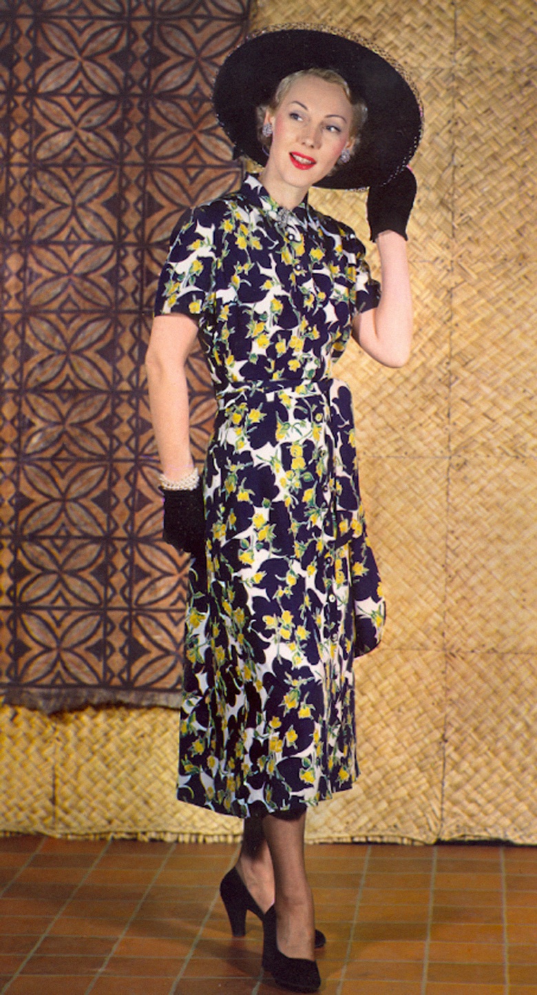  Spring dress with yellow rosebud print, tie belt forming side panels; short cotton gloves; diamond earrings and pearl bracelets; opera pumps; wide-brimmed hat. Unknown photographer. Timeline Archive