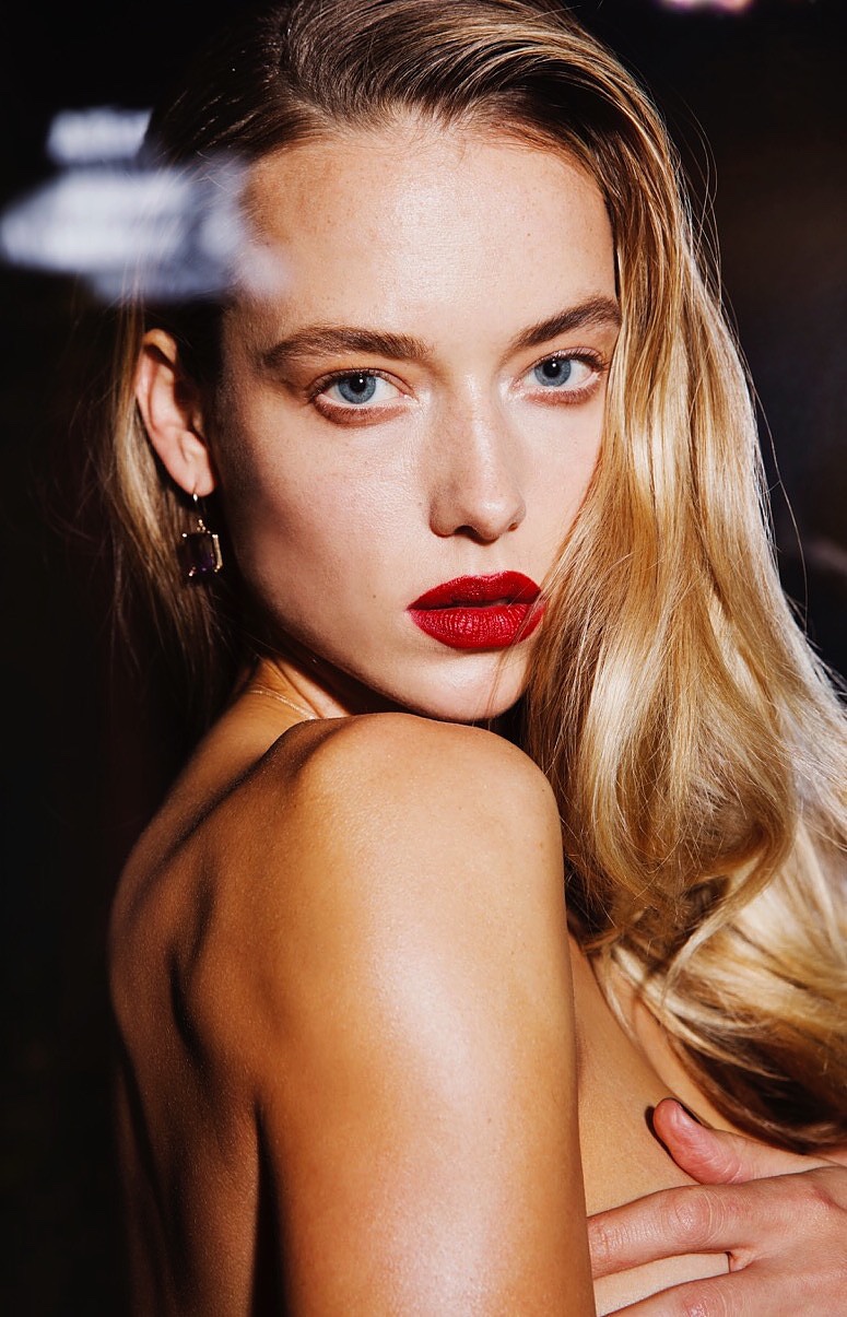 The model wears her hair in glamorous waves with a siren red lipstick shade