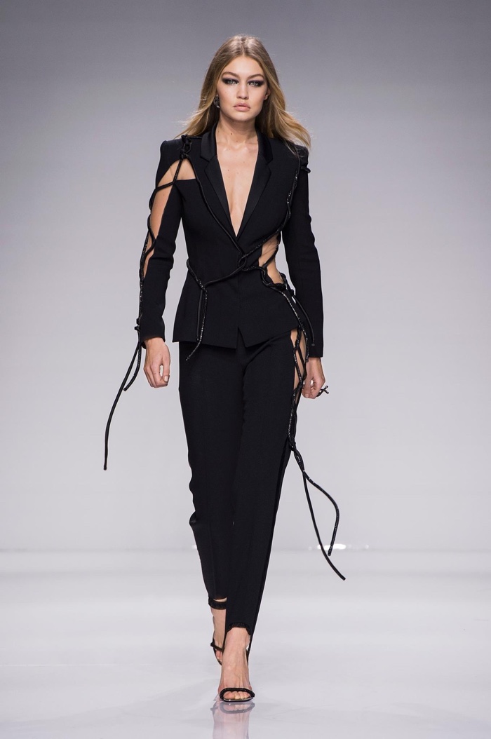 Gigi Hadid walks Atelier Versace's spring 2016 show wearing a black pantsuit with cut-out details