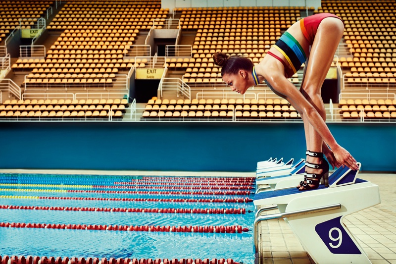 The model poses poolside in sporty inspired fashions