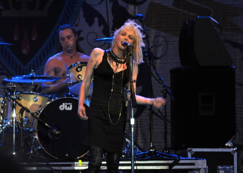 2010: Courtney Love performs on stage with her band Hole, wearing a black dress and matching choker. Photo: Paul McKinnon / Shutterstock.com