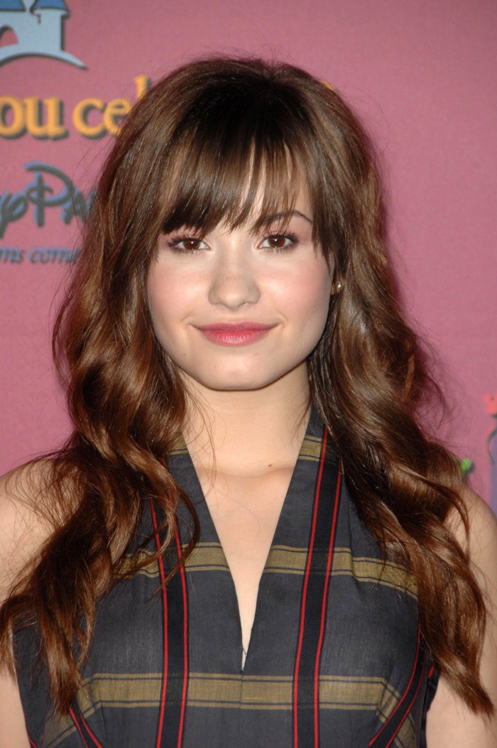 As a fresh face on the scene in 2008, Demi attends a Disney event with her brown hair in long waves and wearing a side bang. Photo: Everett Collection / Shutterstock.com