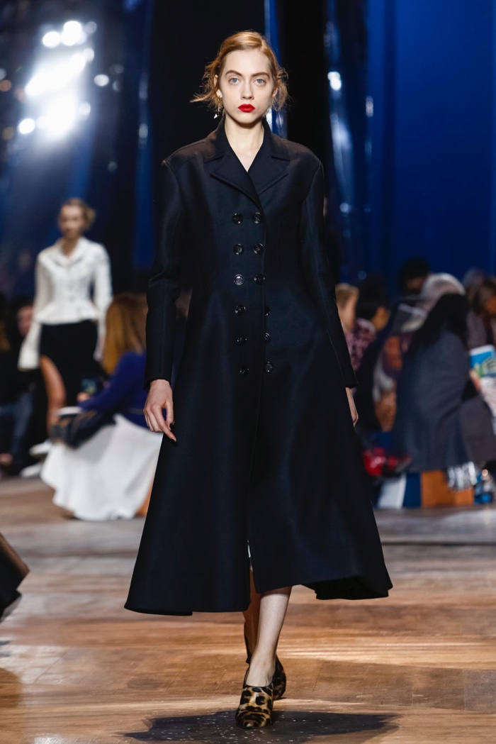 A model walks Dior's spring 2016 show in black coat with flared hem