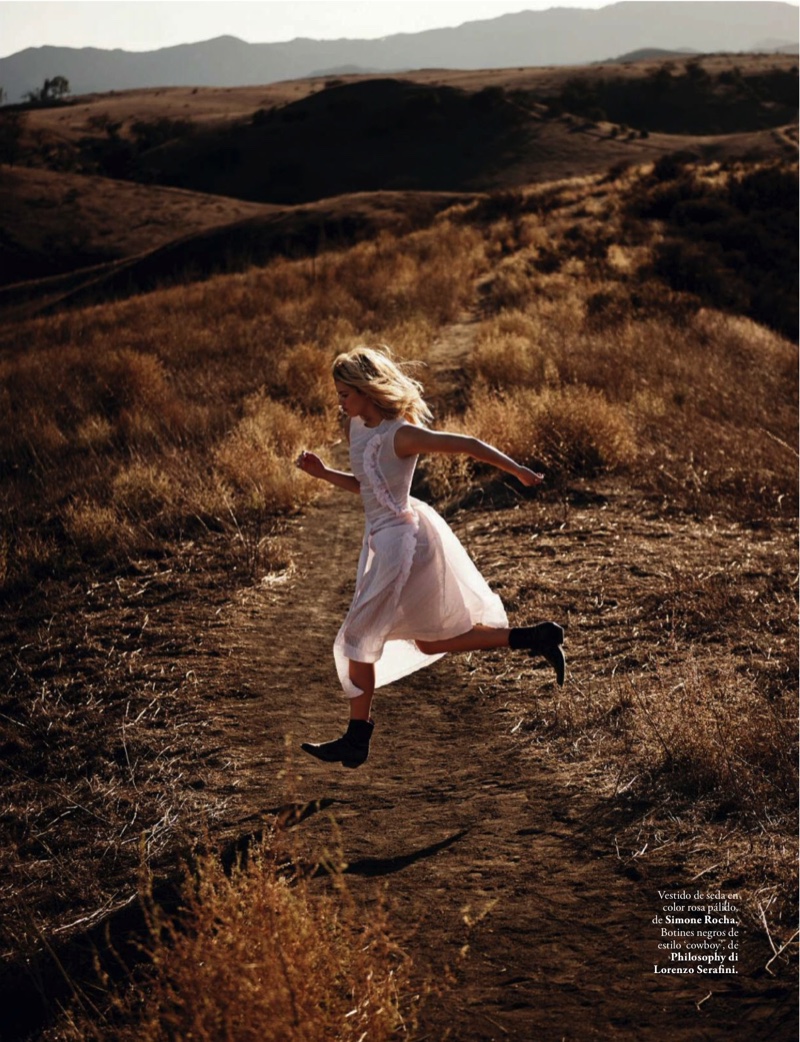 The model runs through an open field in a white dress